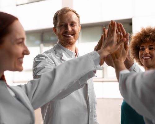 Los técnicos del laboratorio de química se chocan los cinco